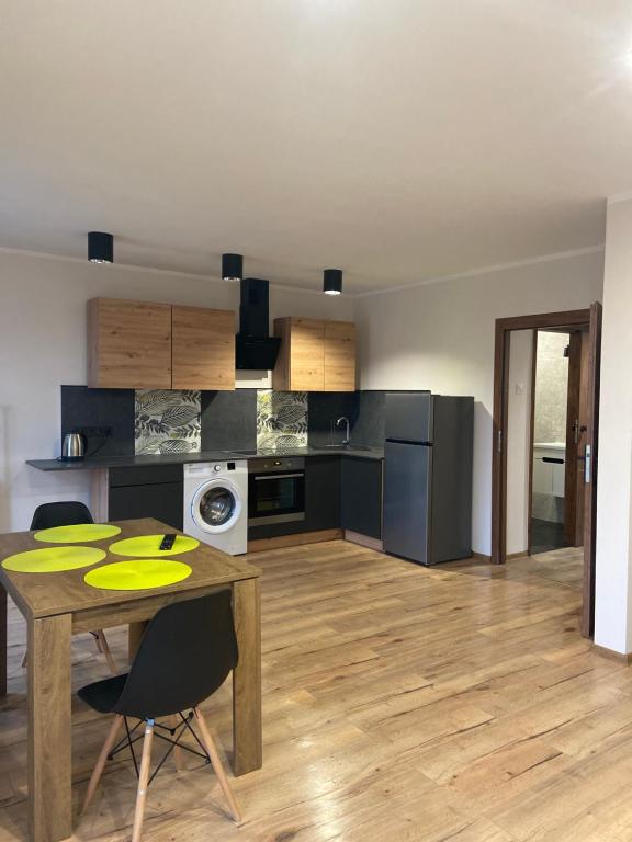 a kitchen with a wooden table and a dining room at Apartamenty Bezrzecze in Szczecin