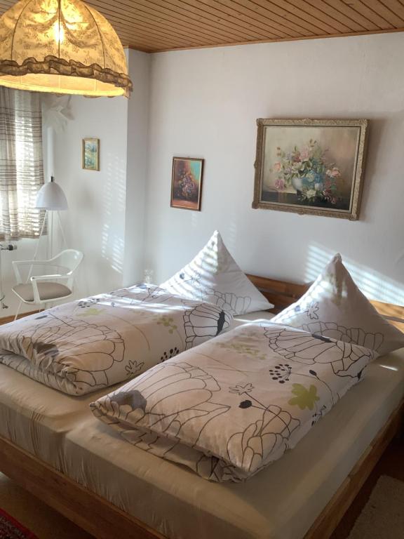 a bedroom with two beds and a table and a lamp at Haus Liesal in Spiegelau