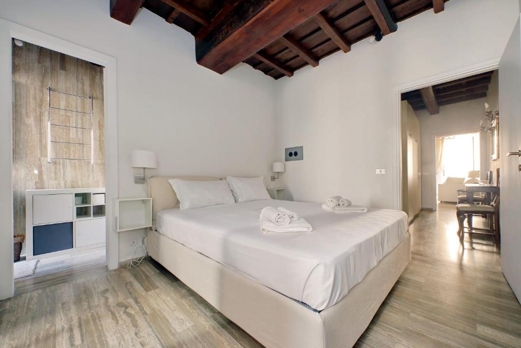 a white bedroom with a large white bed in a room at suity I cozy Nazareno Apartment in Rome