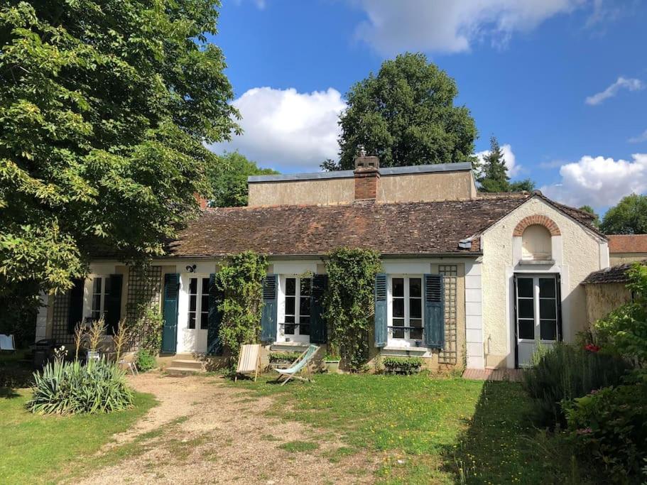 une vieille maison avec une cour d'herbe devant elle dans l'établissement Country house - 5 mns from Fontainebleau, 