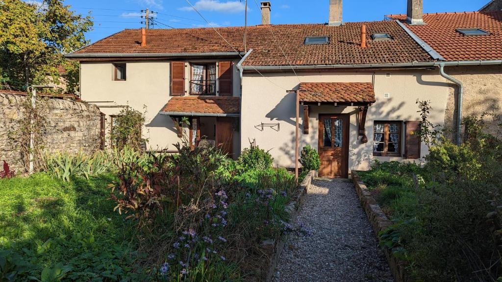 una casa blanca con un jardín delante de ella en Gîte de la Harpe au 4, en Vauvillers