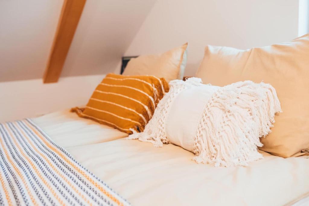 eine Gruppe von Kissen auf einem Bett in der Unterkunft Ograda Magura village in Măgura