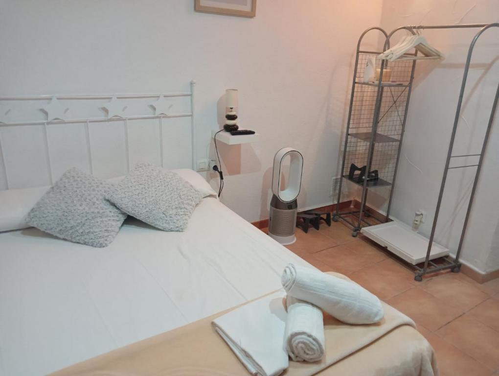 1 dormitorio con cama blanca y espejo en Cau d'en Magí - Apartament Casc Antic, en Tarragona