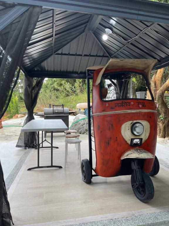 a small rv parked under a tent with a table at Star & Moon GUEST HOUSE in Hengchun South Gate
