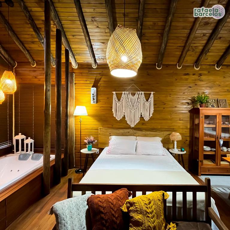 een slaapkamer met een groot bed in een houten kamer bij Vale das Águas Chalé in Treviso