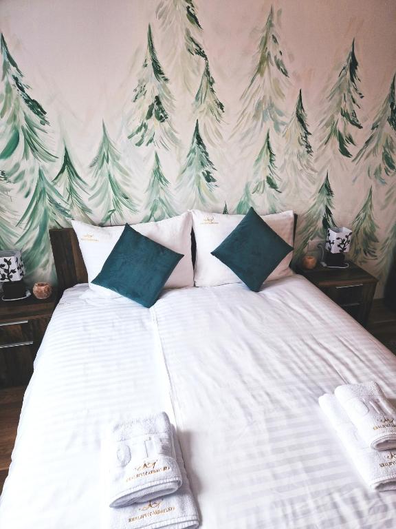 una camera da letto con un letto bianco e alberi sul muro di Cozy Forest Kopaonik a Kopaonik