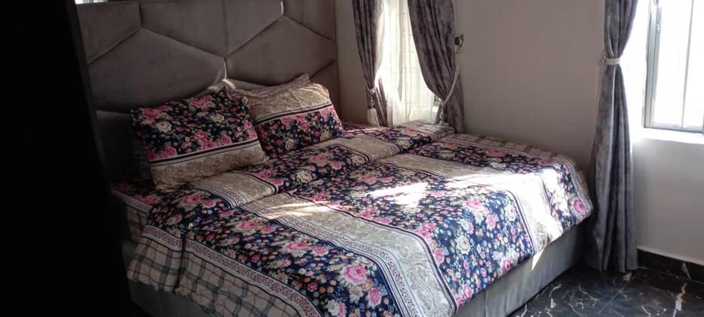 a bedroom with a bed with a large headboard at Remarkable 2-Bed Apartment in Asaba in Asaba