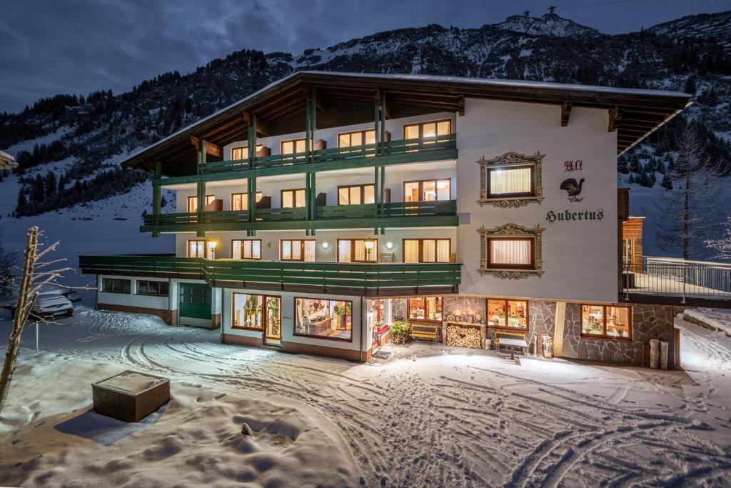 un gran edificio en la nieve por la noche en Hubertus, 3 Sterne Superior, en Lech am Arlberg