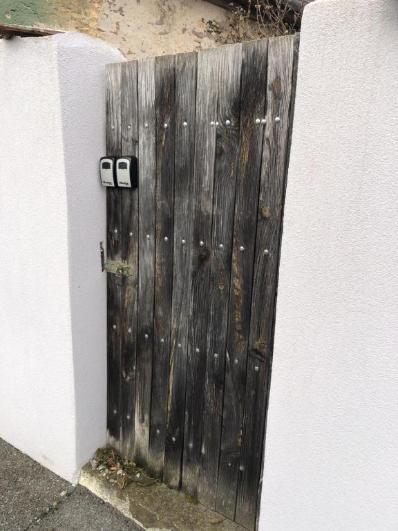 una porta di legno con due telecamere sul lato di un muro di Le Megève a Sainte-Croix-en-Plaine