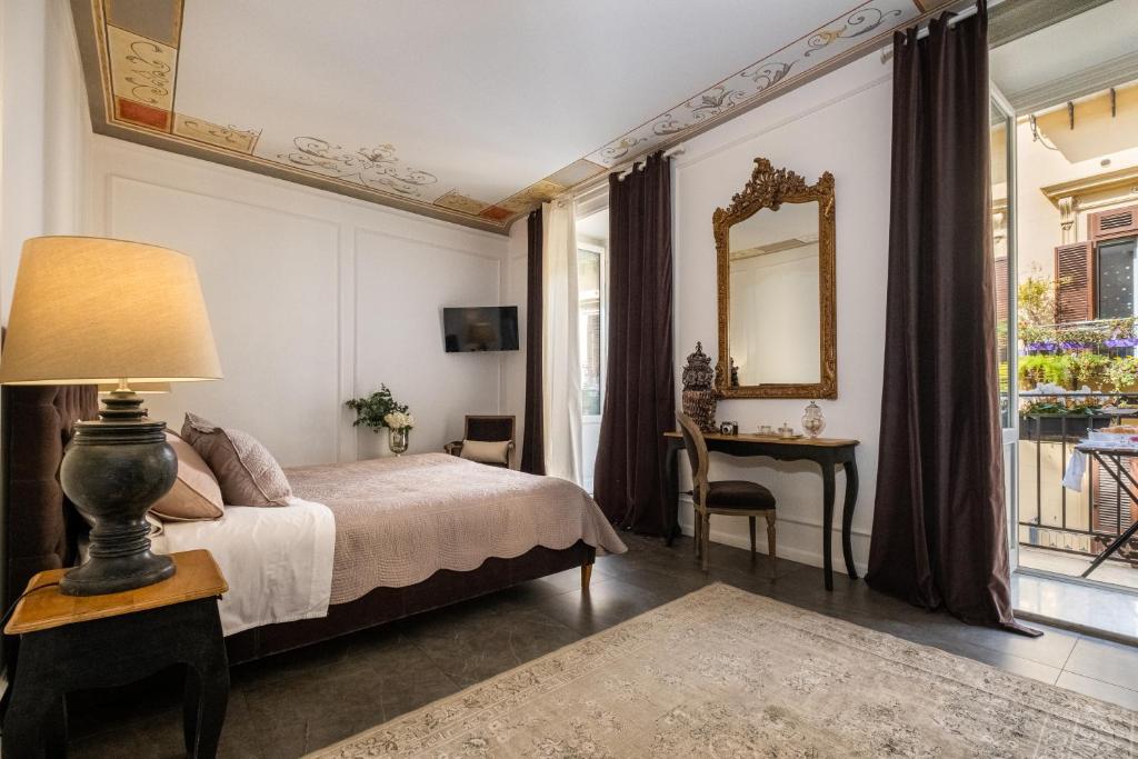 a bedroom with a bed and a mirror and a table at Palazzo Natoli Boutique Hotel in Palermo