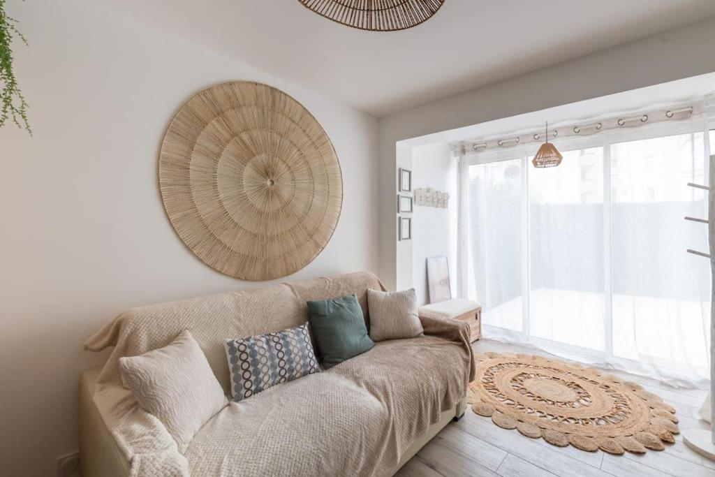 un salon avec un canapé et une grande fenêtre dans l'établissement La Perle du Port * Terrasse * clim * mer à 5 min * chambre *, à Carnon-Plage
