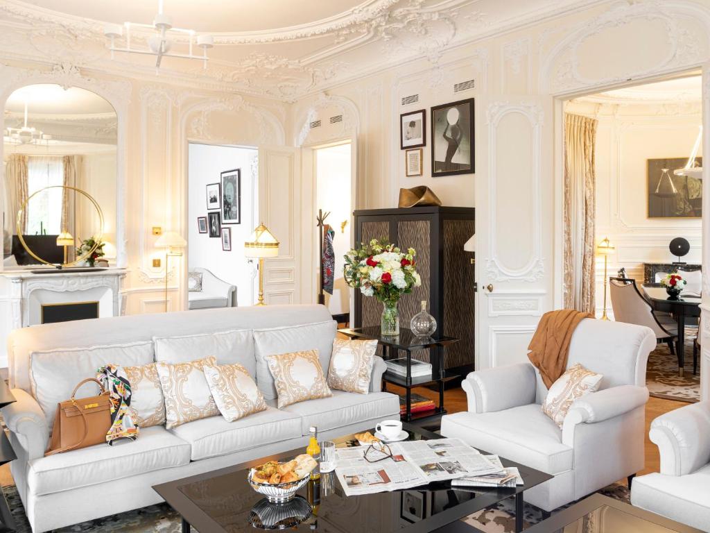 a living room with a white couch and a table at Hôtel Barrière Fouquet's Paris in Paris