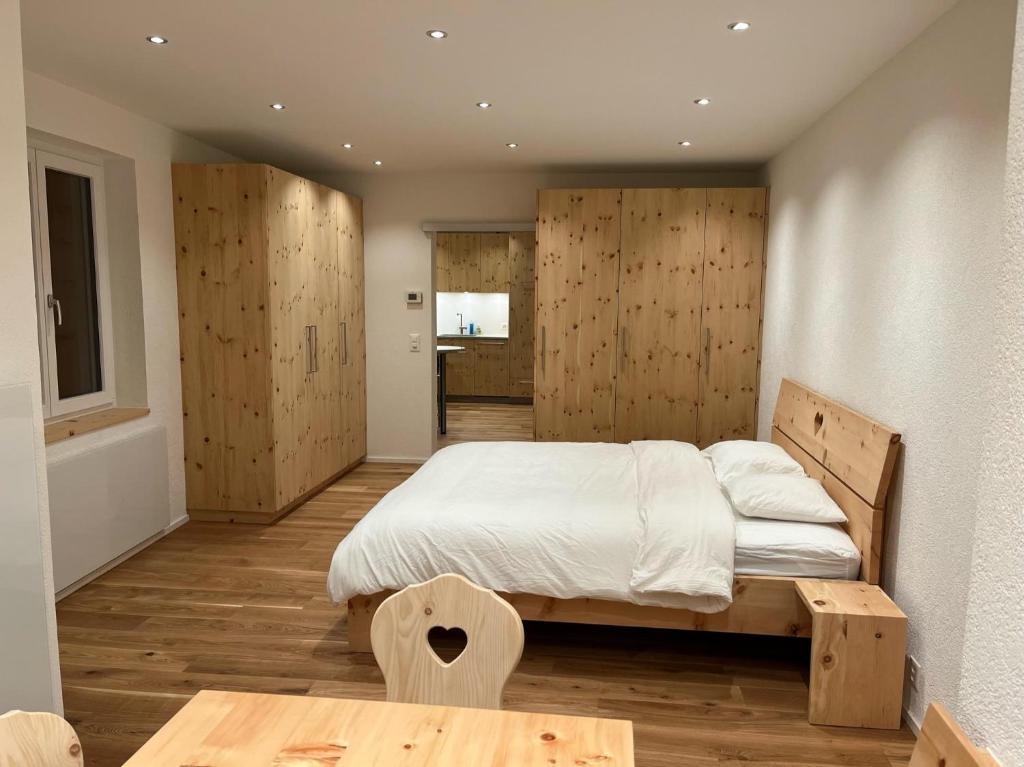una camera con un grande letto e pareti in legno di Zum Rota Hus a Arosa