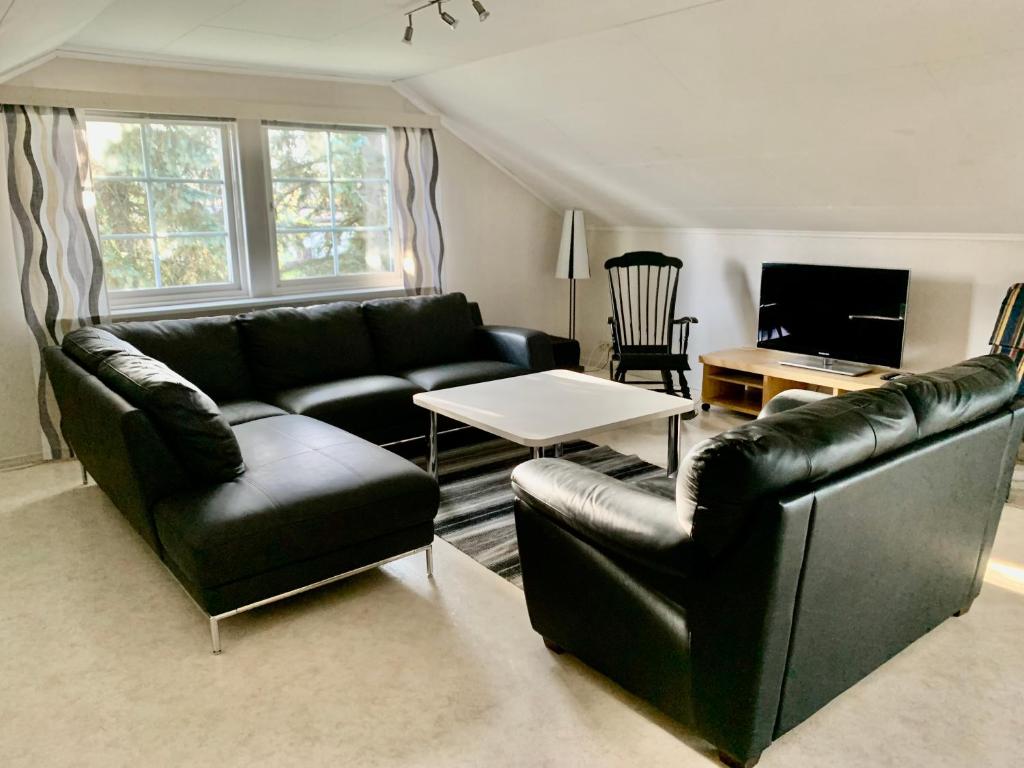 a living room with two leather couches and a table at Central Apartment Närpes in Närpiö