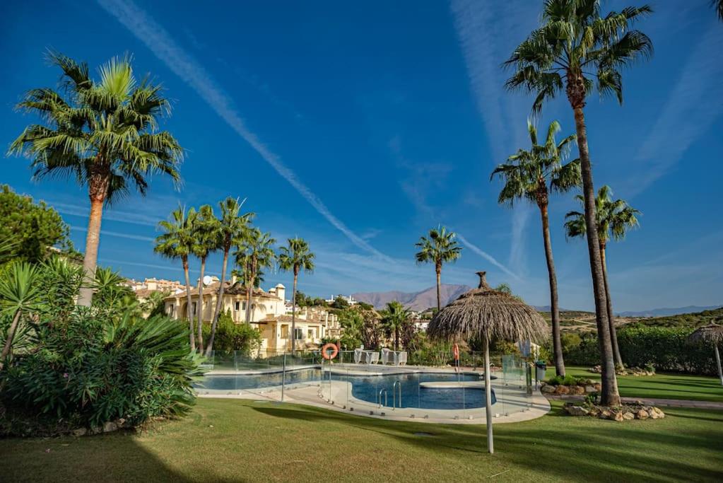 a resort with a swimming pool and palm trees at Spacious ground floor apartment in Casares Costa in Casares