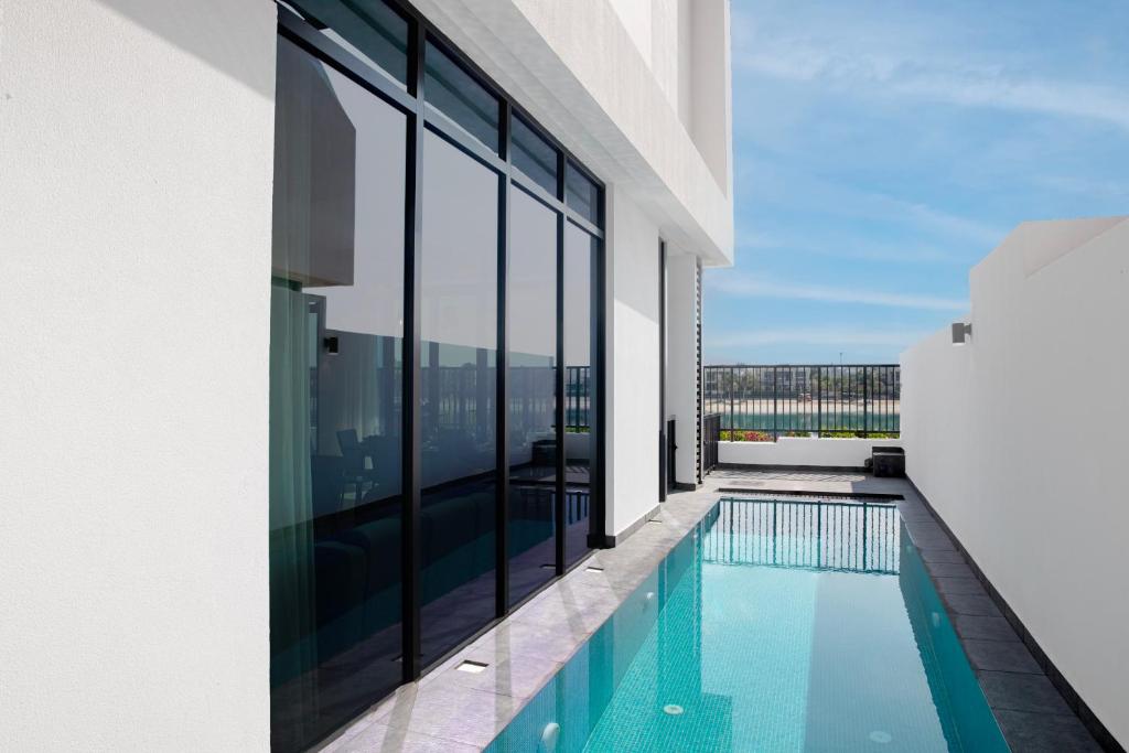 a swimming pool on the side of a building at Beach Villas by Olala Homes in Ras al Khaimah