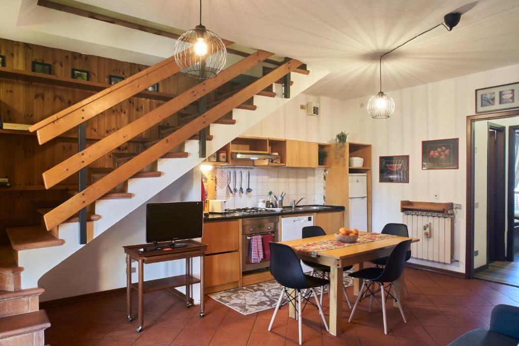eine Küche mit einer Treppe und einem Tisch mit Stühlen in der Unterkunft Little Brick House on Siena Hills with Balconies in Siena