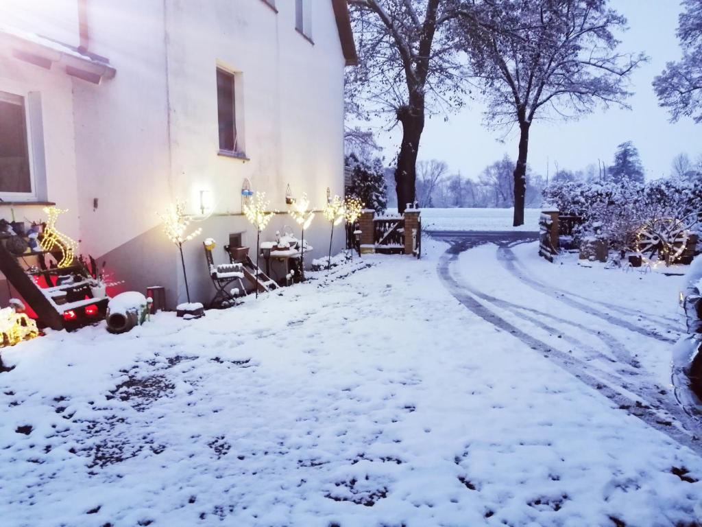 a yard covered in snow next to a building at Ferienwohnung Monteurzimmer in Plessa