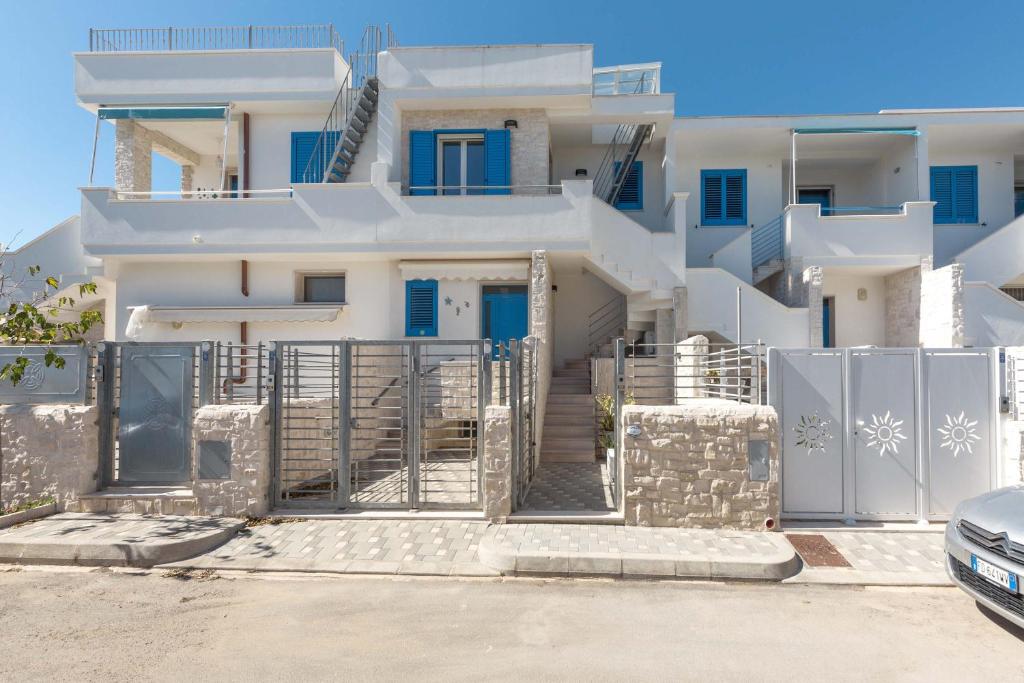 une maison blanche avec des portes bleues et un portail dans l'établissement L`Ebrezza by BarbarHouse, à Campomarino