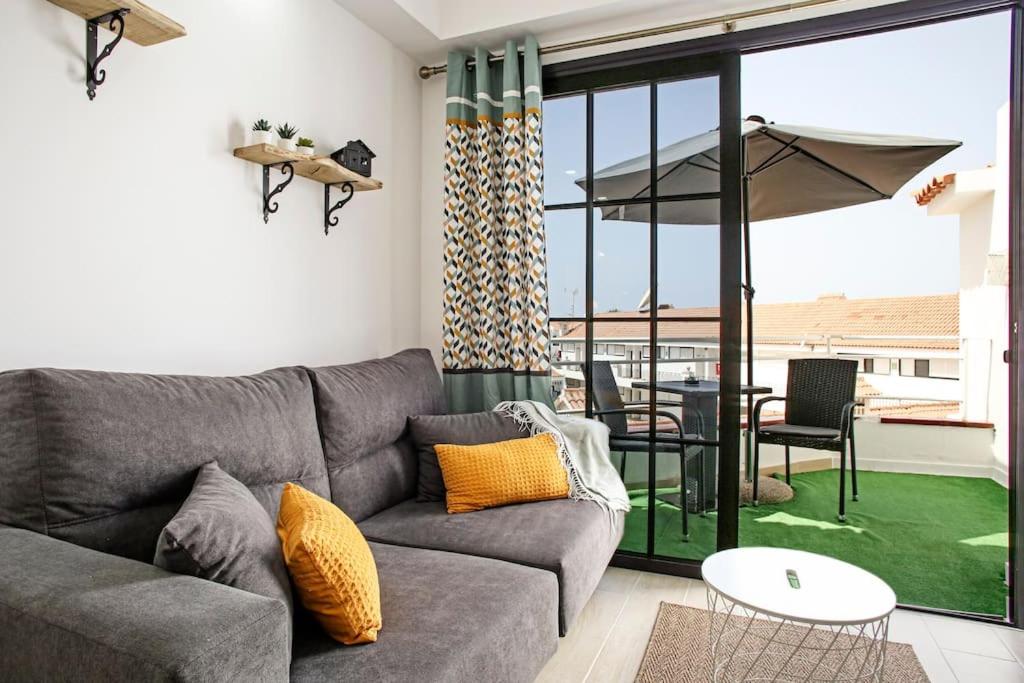 a living room with a couch and a table and a patio at Royal Suite Diamantes I With heated pool in Los Cristianos