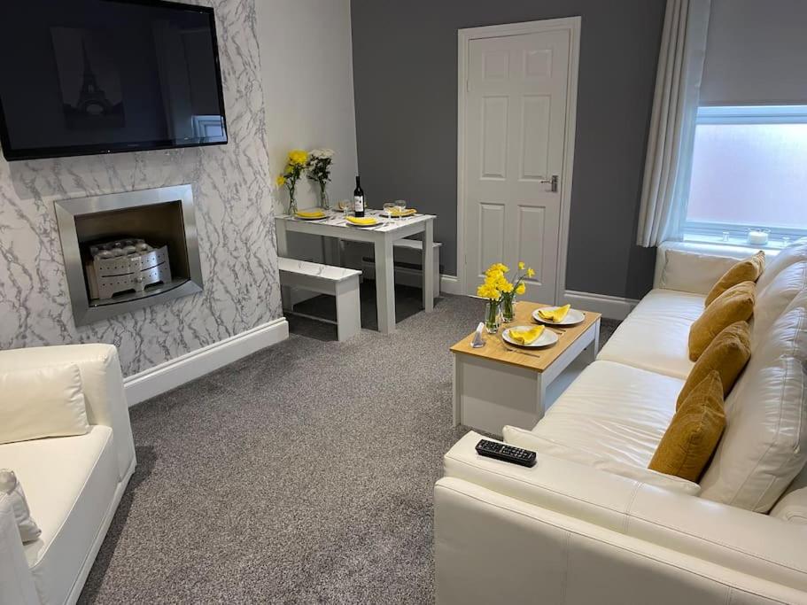a living room with a white couch and a fireplace at Seaside House-NEW DAY PROPERTIES in South Shields