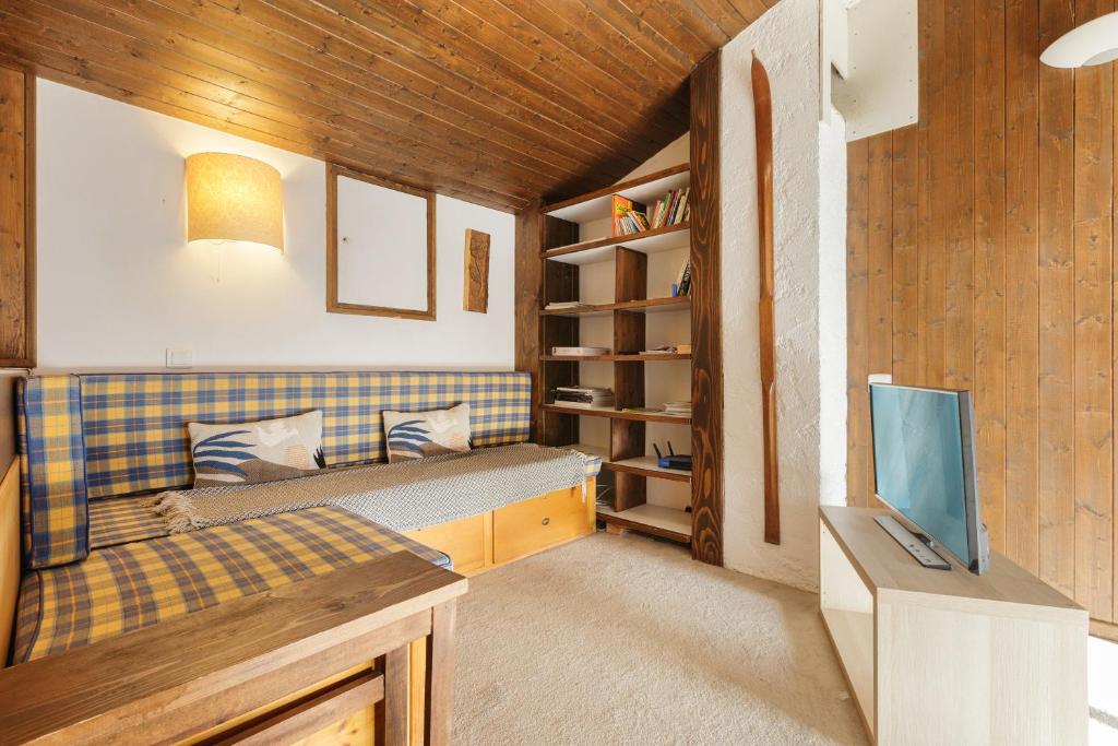 a small room with a couch and a tv at La Maison De Montroc - Happy Rentals in Chamonix