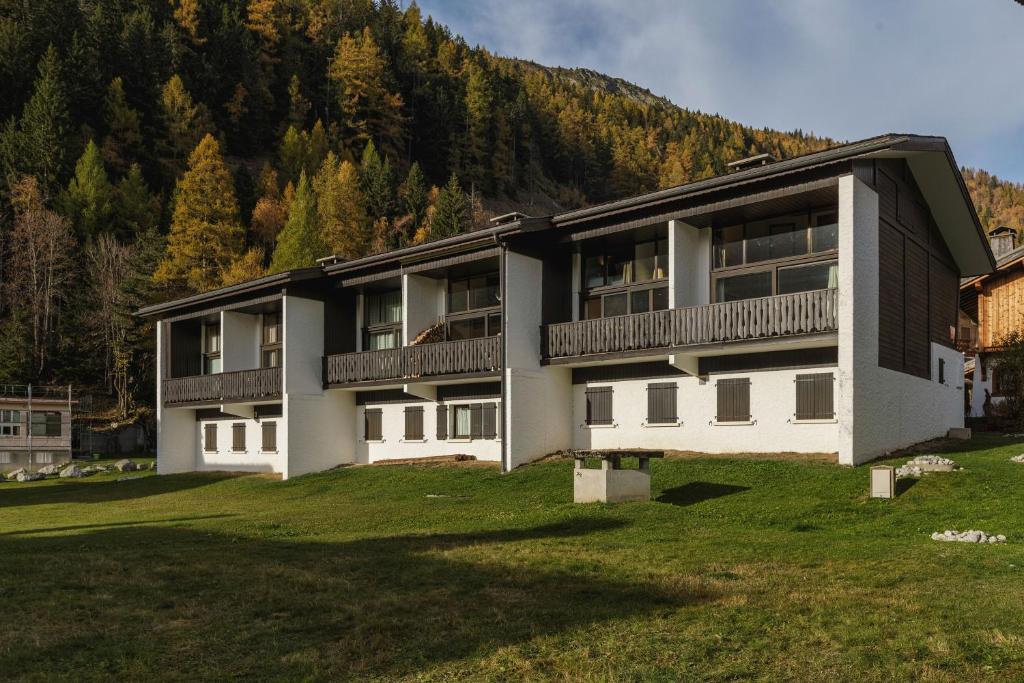 a building with a large yard in front of a mountain at La Maison De Montroc - Happy Rentals in Chamonix