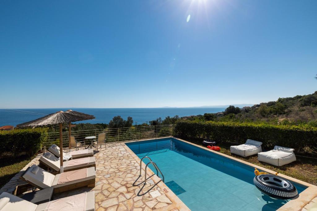 a villa with a swimming pool and a view at Astra Villas in Skala