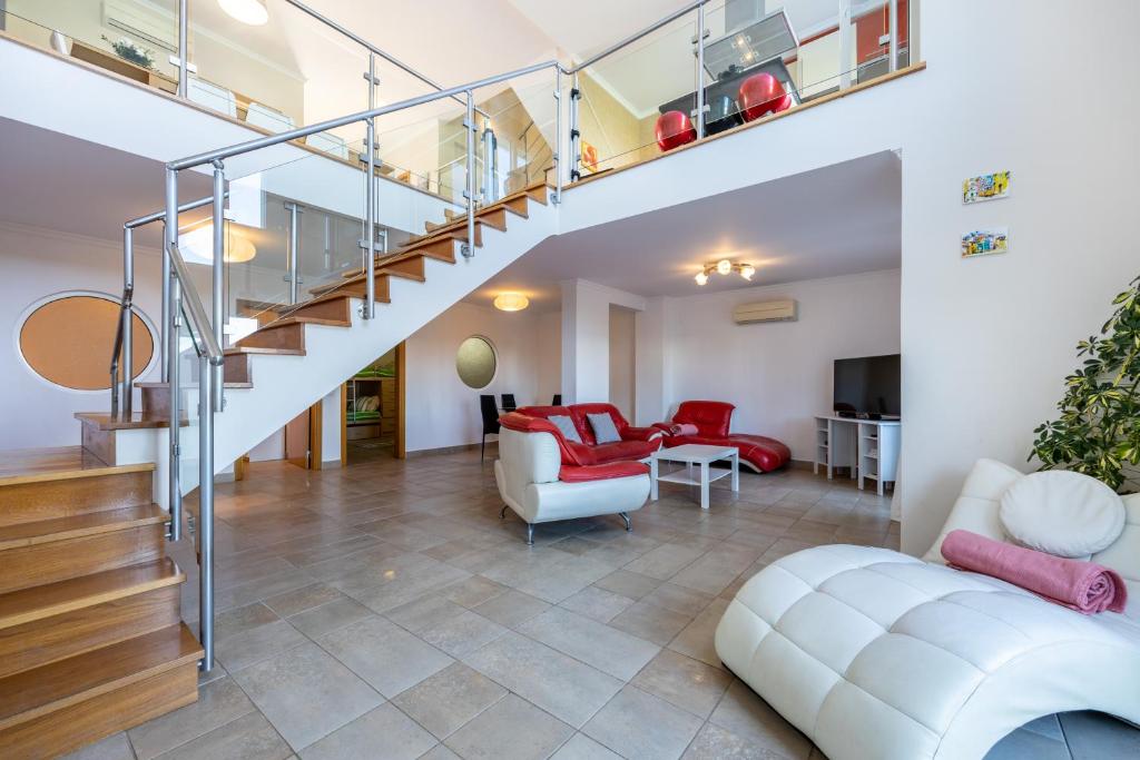 sala de estar de planta abierta con escalera y sala de estar en Your Villa Algarve Private pool 5 min walk to beach, en Burgau