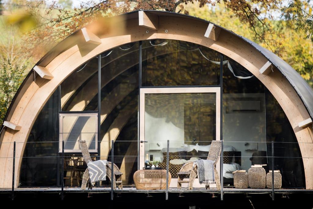 a building with an archway with chairs and a table at Luxury Glamping Room8 a private hideaway from Brussels in Huldenberg