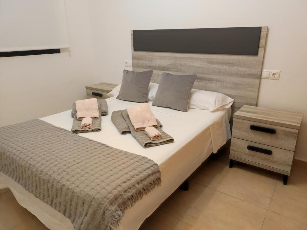 ein Schlafzimmer mit einem Bett mit zwei Handtüchern darauf in der Unterkunft Apartamento Galea in Santa Pola