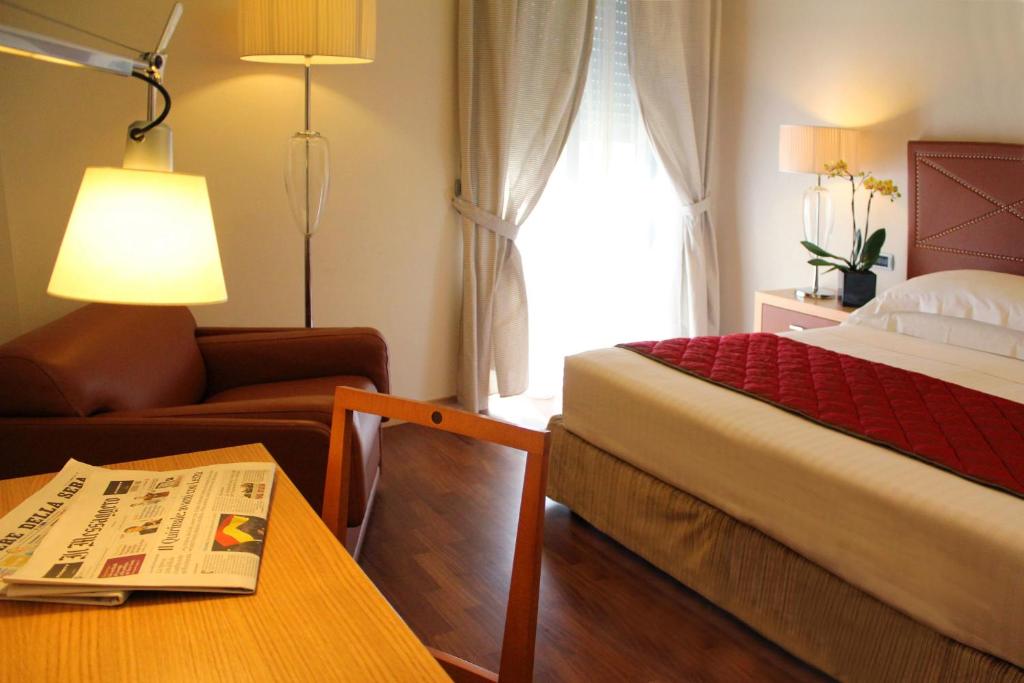 a hotel room with a bed and a table with a newspaper at Hotel Cristallo in Giulianova