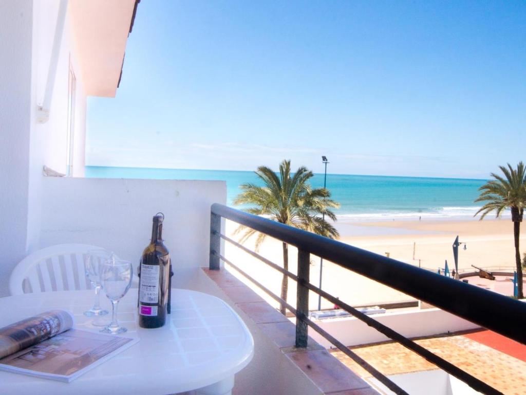 a bottle of wine on a table with a view of the beach at La Barrosa con vistas al mar in Novo Sancti Petri