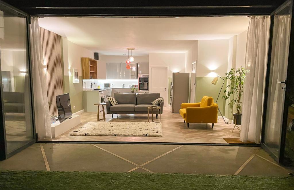 Garden Apartment Winchester في وِنشستير: غرفة معيشة مع أريكة وكرسي أصفر