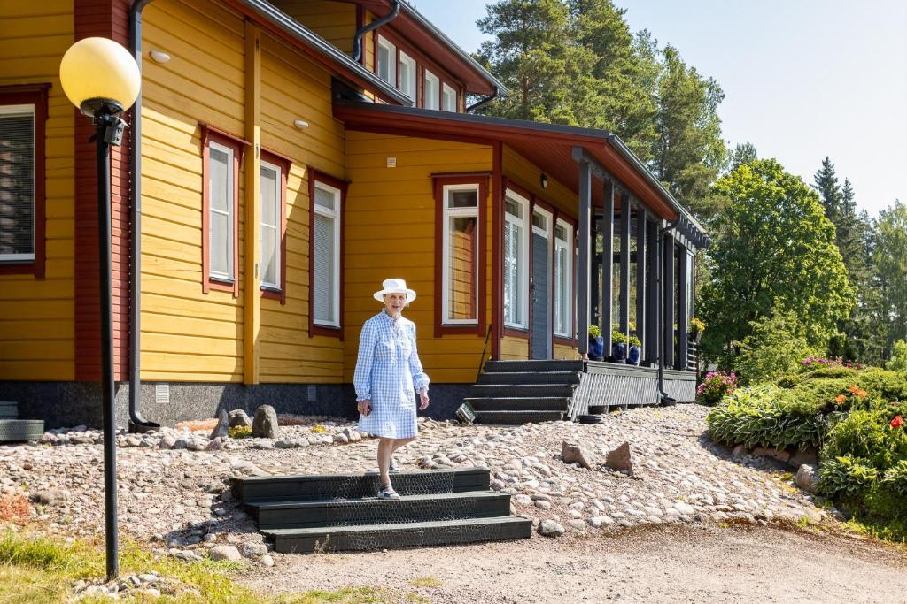 a woman standing in front of a house at Leena's B&B in Inkoo