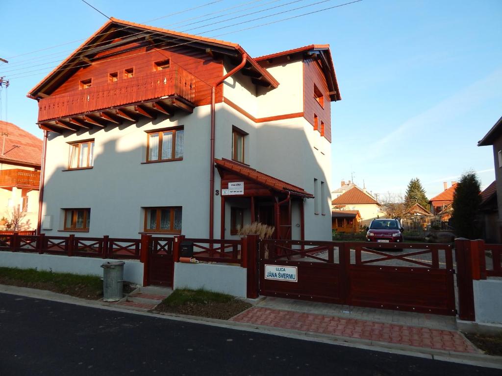 a white house with a red roof and a fence at Privat Liska in Liptovský Mikuláš