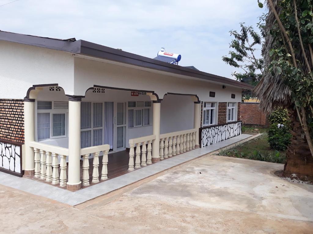 une maison avec une terrasse couverte et une clôture dans l'établissement BIZI HOMES, à Kigali