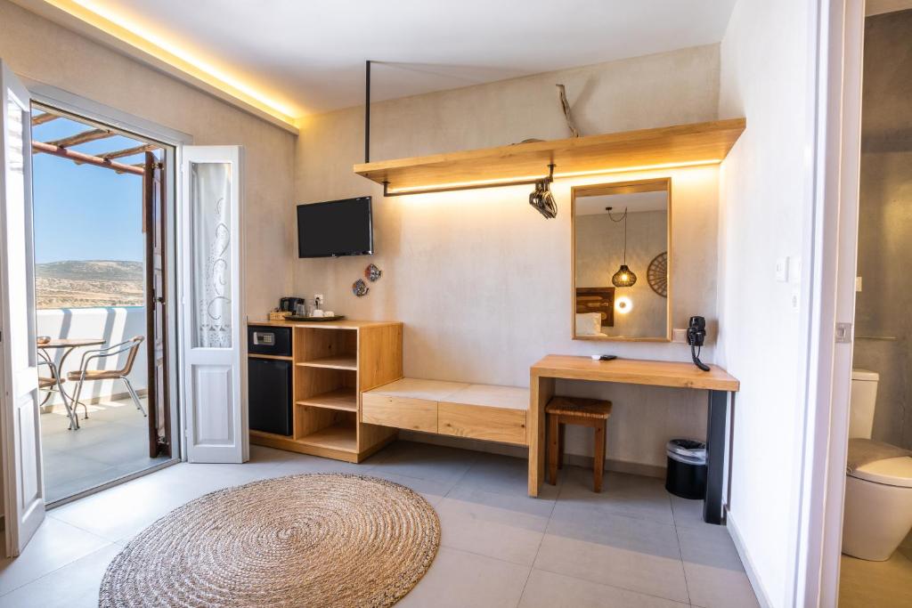 a room with a desk and a sink and a mirror at Aegean Village Beachfront Resort in Amoopi