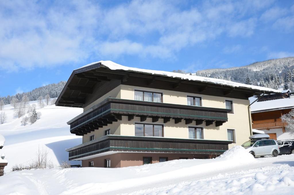 a building with snow on the ground in front of it at Appartement Gundi Ripper in Saalbach-Hinterglemm