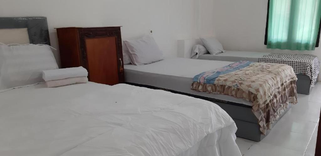 een slaapkamer met 2 bedden en een bank. bij ADELYA HOMESTAY in Praya