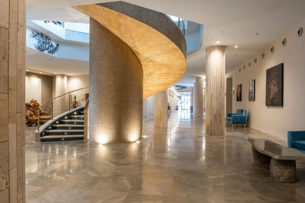 a lobby with a spiral staircase in a building at Cádiz Bahía by QHotels in Cádiz
