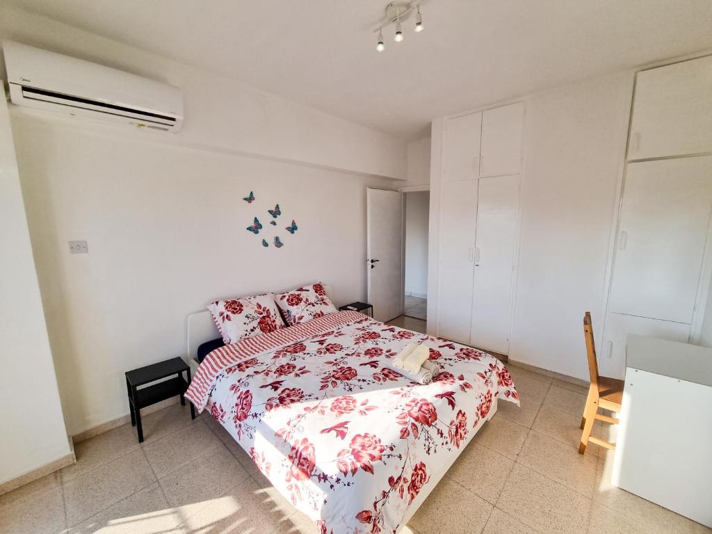 een slaapkamer met een bed met een rood en wit dekbed bij City View Rooms in Larnaka