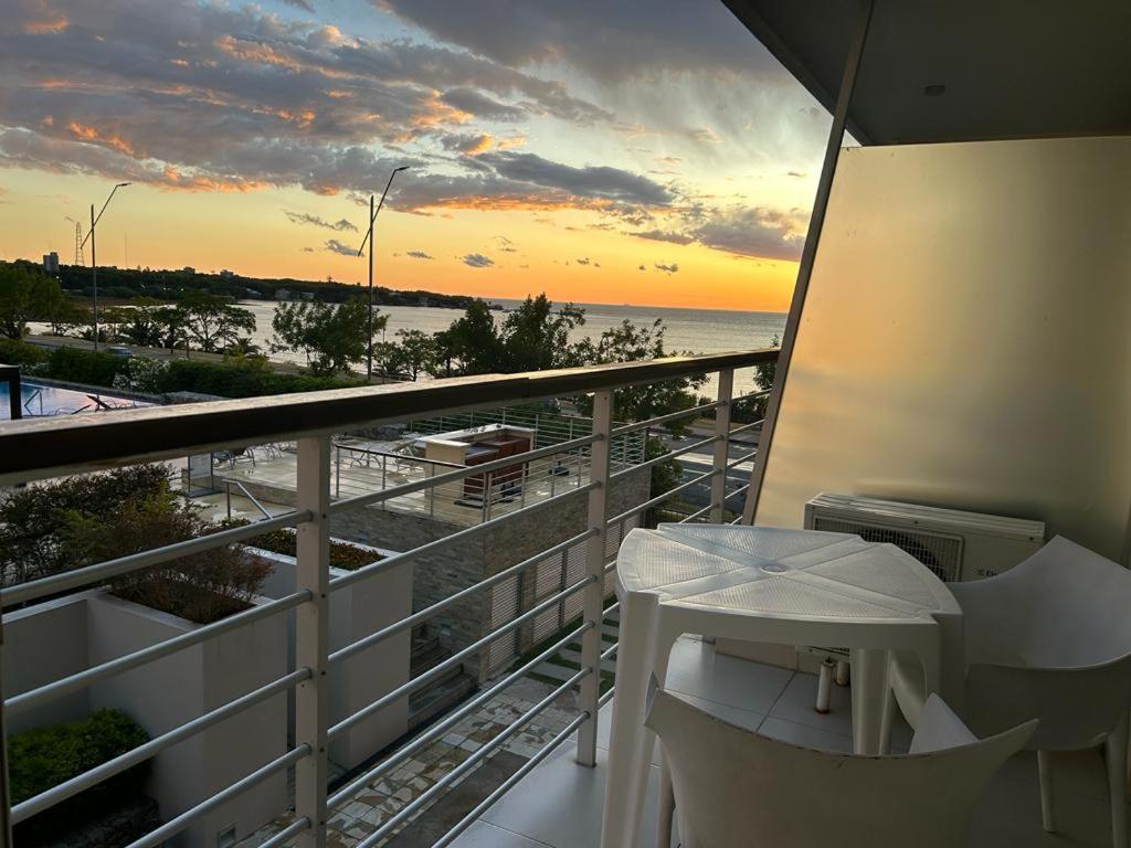 balcón con mesa y vistas al océano en Altos del Virrey 204 apartamento frente al río, en Colonia del Sacramento