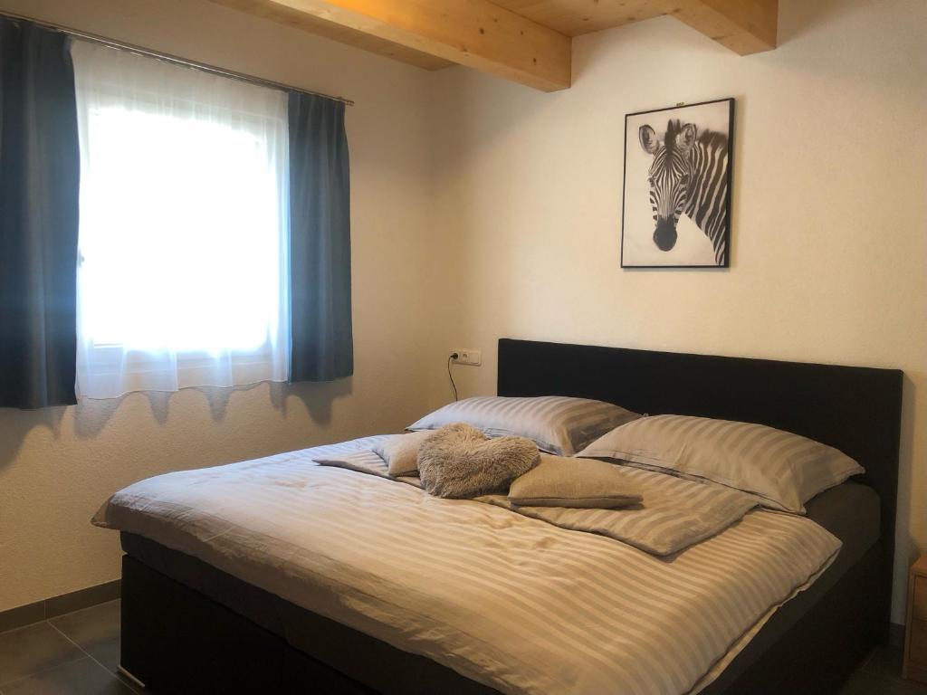 a bedroom with a bed with a zebra picture on the wall at Ferienwohnungen zum Klammlhof in Ebene Reichenau