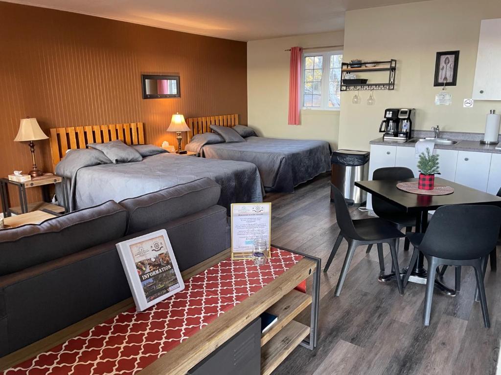 une chambre d'hôtel avec deux lits et une cuisine dans l'établissement Auberge et Chalets sur le Lac, à Lac-Mégantic