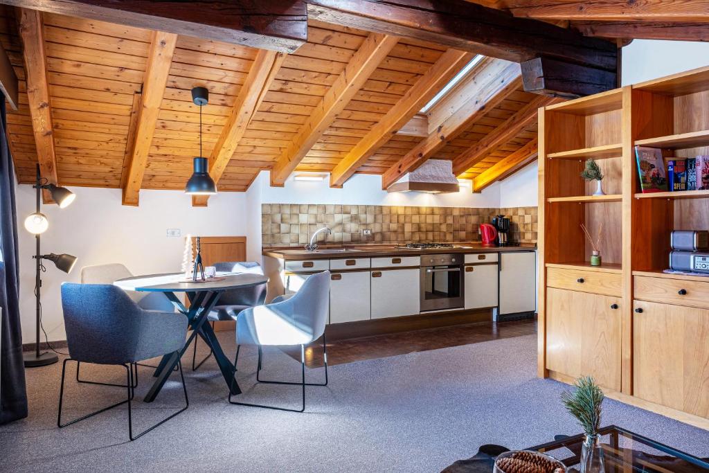 een keuken met een tafel en stoelen in een kamer bij Sirena Carezza Apartment Masarè in Carezza al Lago