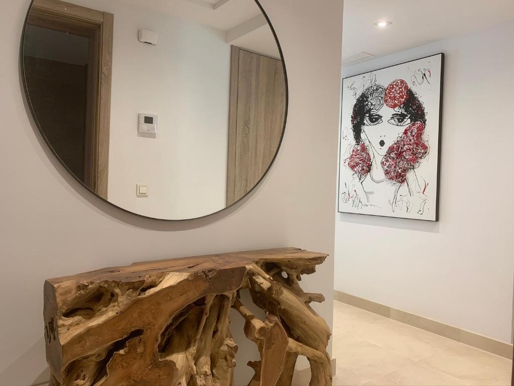 un espejo en una pared junto a una mesa de madera en Royal Banus, en Marbella