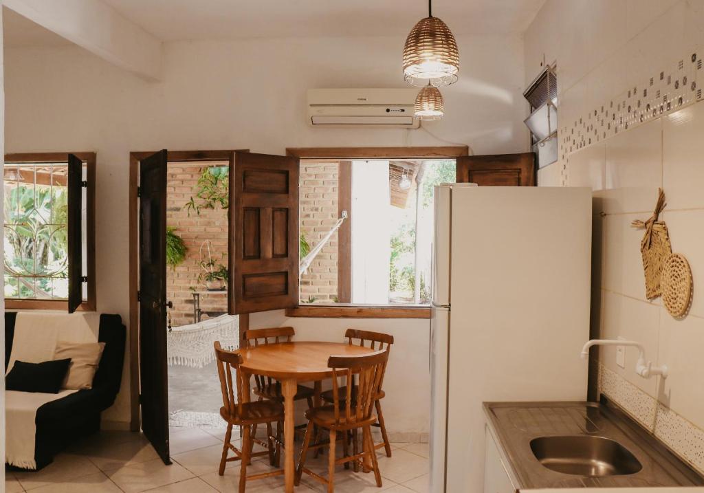 a kitchen and dining room with a table and a refrigerator at Flats Beija-flor Itacaré in Itacaré