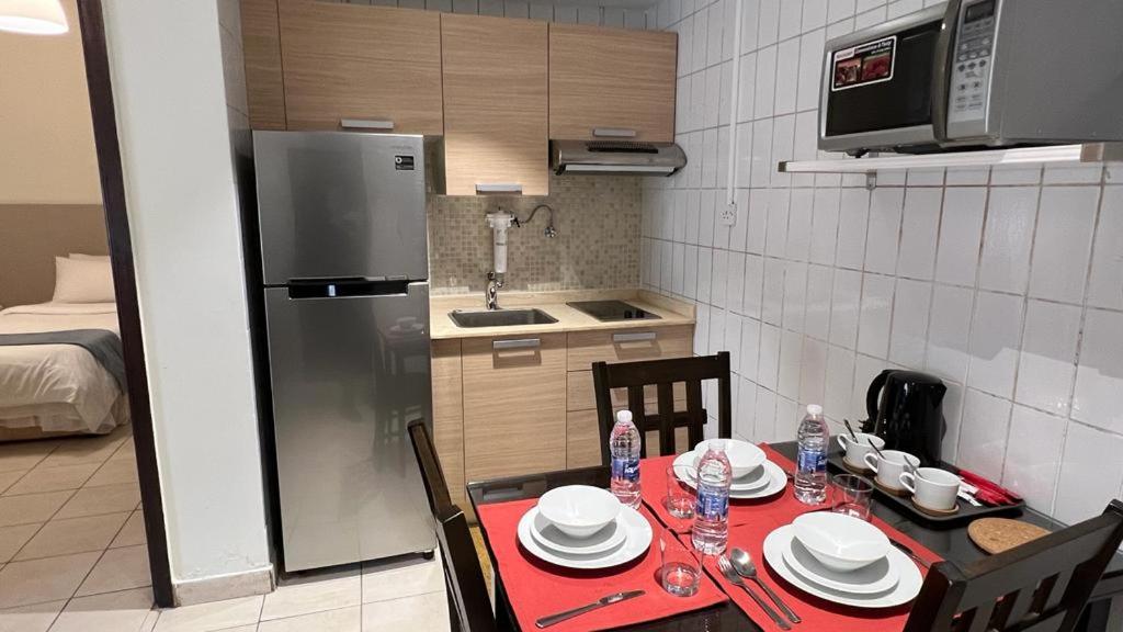 a small kitchen with a table with a red table cloth at Kuwait Residence in Kuwait