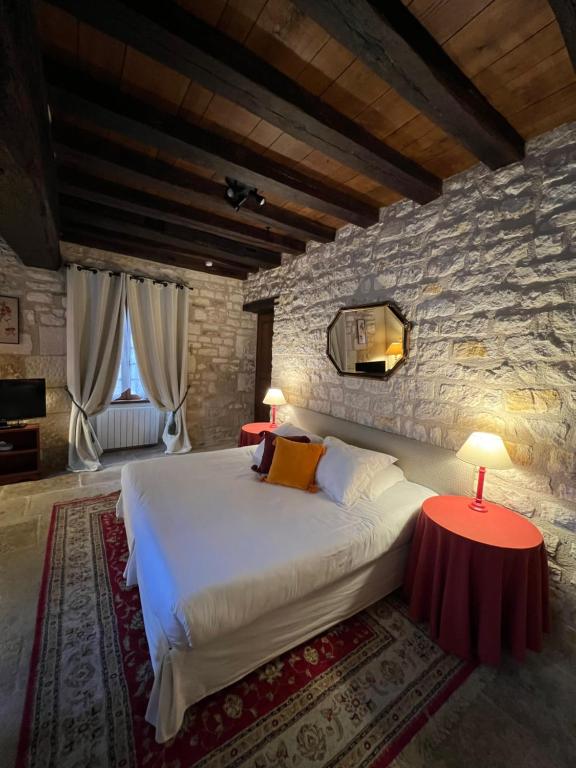 a bedroom with a large bed and two tables at La Maison d'Alienor, Gite à Chablis in Chablis